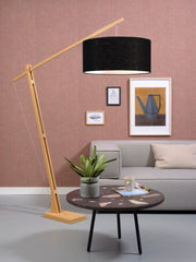 Gesamtansicht der Stehleuchte Good&Mojo Montblanc mit schwarzem Leinenschirm und Bambusgestell vor rosa Wand.