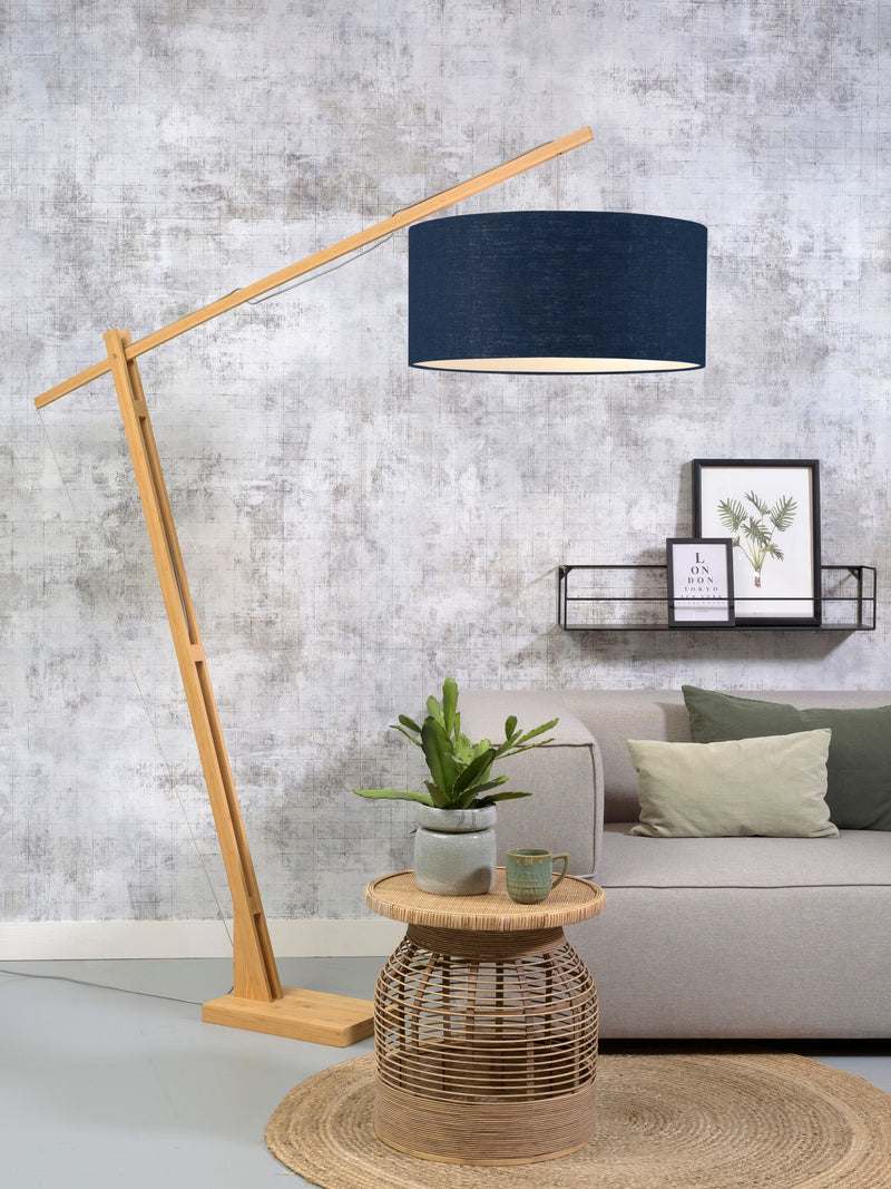Stehleuchte Montblanc von Good&Mojo mit Bambusgestell und dunkelblauem Leinenschirm, im Wohnzimmer vor grauer Wand.