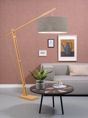 Gesamtansicht der Stehleuchte Good&Mojo Montblanc mit schwenkbarem Bambusgestell und dunklem Leinenschirm im Wohnraum.