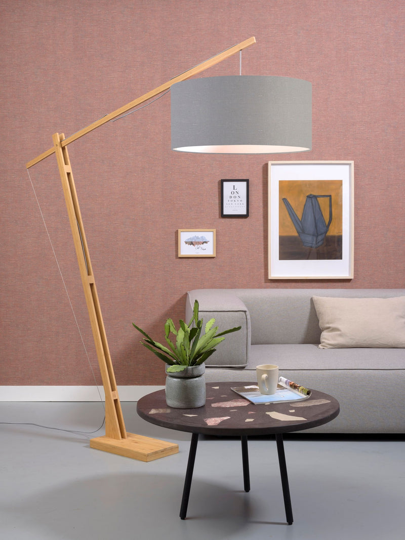 Gesamtansicht der Stehleuchte Good&Mojo Montblanc mit schwenkbarem Bambusgestell und hellgrauem Leinenschirm vor rosa Wand.