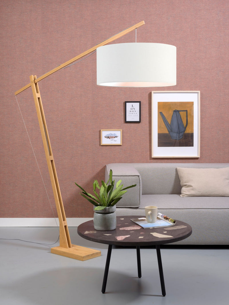 Gesamtansicht der Stehleuchte Good&Mojo Montblanc mit hellem Leinenschirm über einem Sofa im Wohnraum.