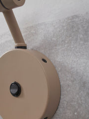It’s about RoMi Wandleuchte Montreux in Sand: Detailansicht der runden Wandbefestigung mit Schalter und Gelenkarm aus Eisen.