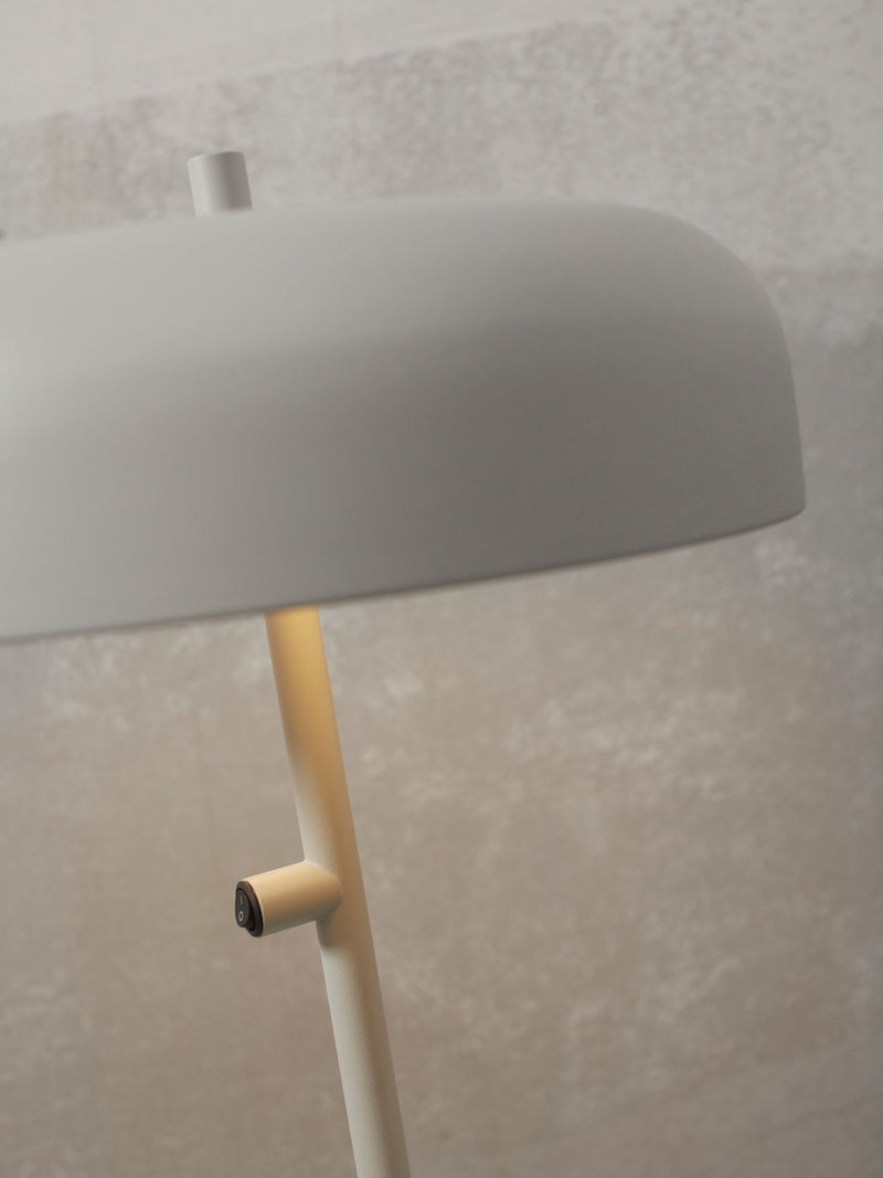 Detailansicht des runden Metallschirms und des Schalters am schlanken Gestell der RoMi Tischleuchte Porto L in Hellgrau.