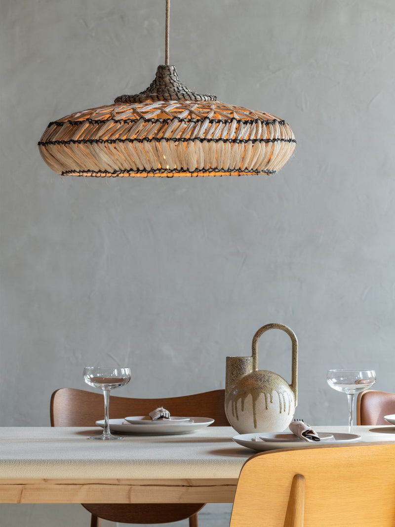 Good&Mojo Hängeleuchte Rinjani aus Abaka in Natur über einem gedeckten Esstisch mit Keramikkrug und Gläsern.