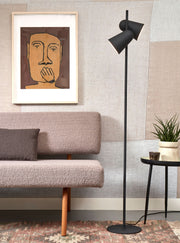Stehleuchte Salamanca von It's about RoMi mit zwei schwenkbaren schwarzen Eisen-Spots neben Sofa und Beistelltisch.