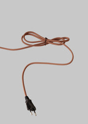 Gewebeummantelte Stromleitung in Terrakotta mit schwarzem Eurostecker und Kabelbinder auf grauem Hintergrund.