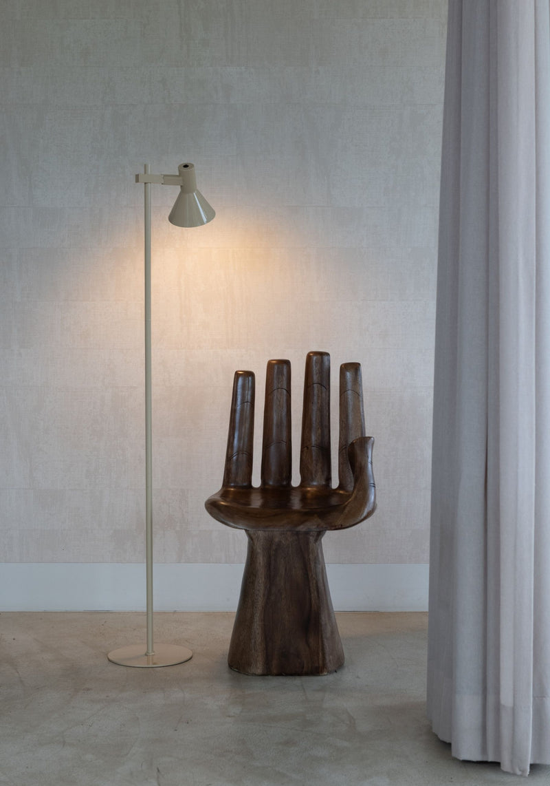 Stehleuchte "It's about RoMi Stavanger" in Beige mit schlankem Eisengestell und konischem Schirm, daneben Holzsessel.