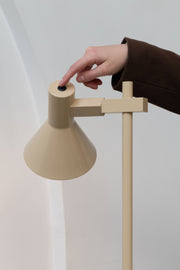 Beige Stehleuchte It's about RoMi Stavanger mit konischem Schirm, Schalter am Schirmkopf wird von einer Hand betätigt.