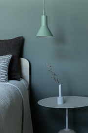 It’s about RoMi Hängeleuchte Stavanger in Grün, mit kegelförmigem Metallschirm über einem Bett und Beistelltisch.