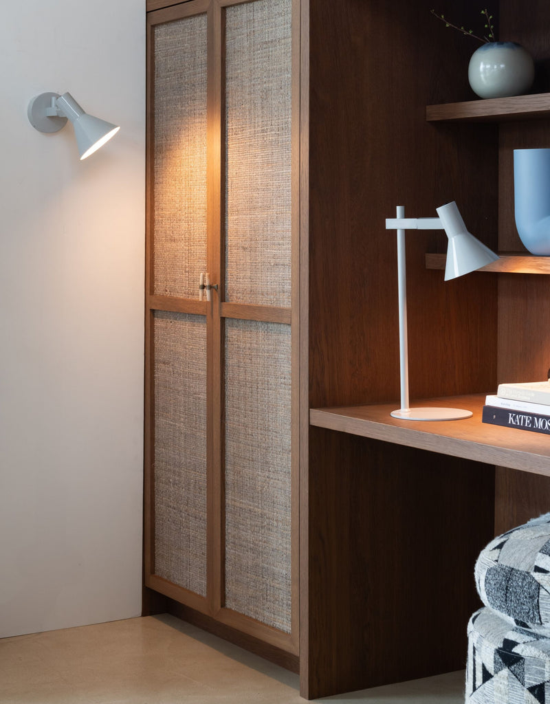 Hellgraue Wandleuchte Stavanger aus Eisen mit schwenkbarem Schirm, an heller Wand neben Holzschrank.
