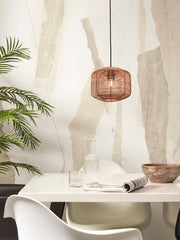 Hängeleuchte Tanami aus Rattan mit Eisengestell in Natur, über einem weißen Esstisch mit Glas und Holzschale.