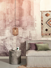 Hängeleuchte Tanami aus Rattan mit Eisengestell in Natur, über einem Sofa mit rosa Wandgestaltung.