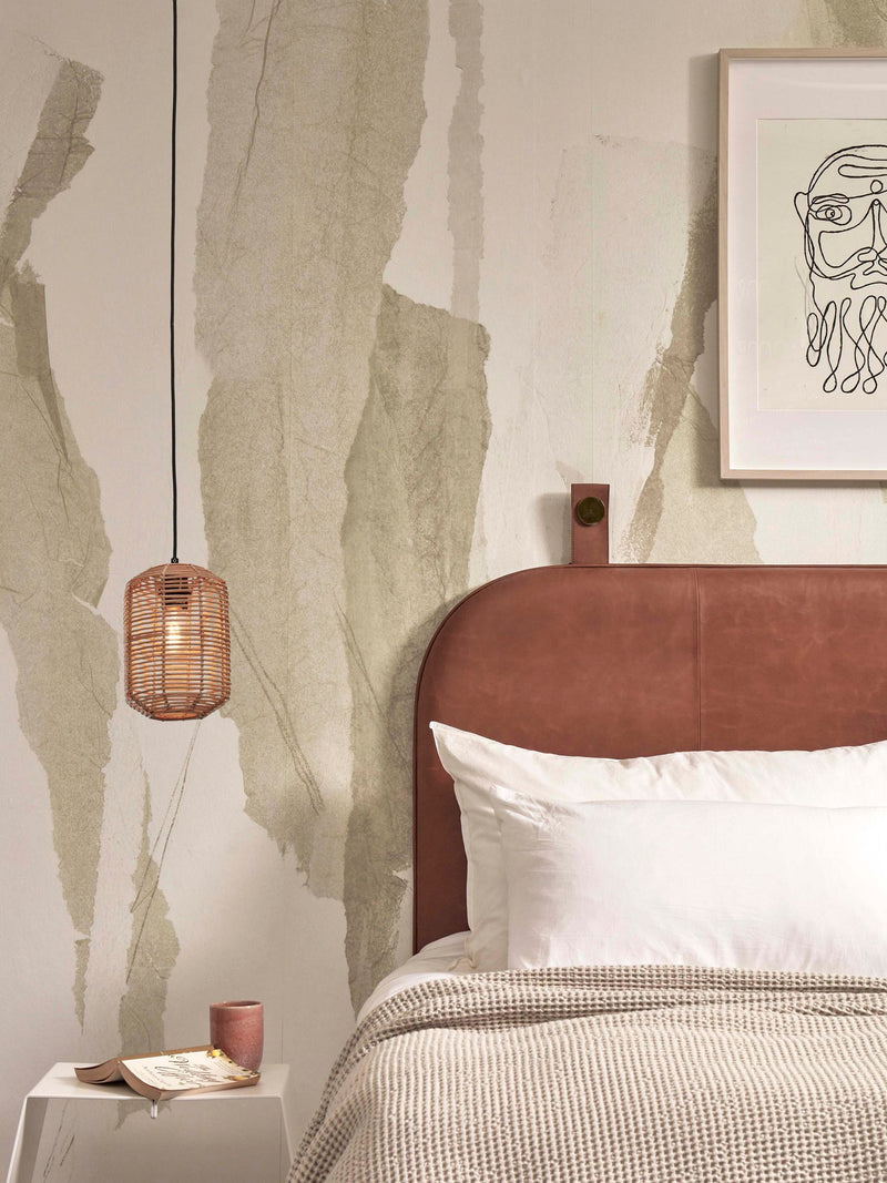Hängeleuchte Tanami aus Rattan in Natur, im Schlafzimmer über dem Nachttisch mit Lederkopfteil und Wandkunst.