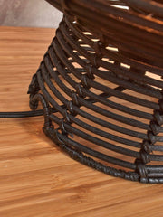 Detailansicht des schwarzen Rattan-Geflechts am Schirm der Tischleuchte Good&Mojo Tanami, auf einer Holzoberfläche.