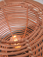Detailansicht des geflochtenen Rattan-Schirms der Good&Mojo Tischleuchte Tanami, durch den die leuchtende Glühbirne sichtbar ist.
