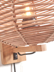 Detailansicht der Good&Mojo Wandleuchte Tanami mit geflochtenem Rattan-Schirm, leuchtender Glühlampe und Bambus-Wandhalterung.