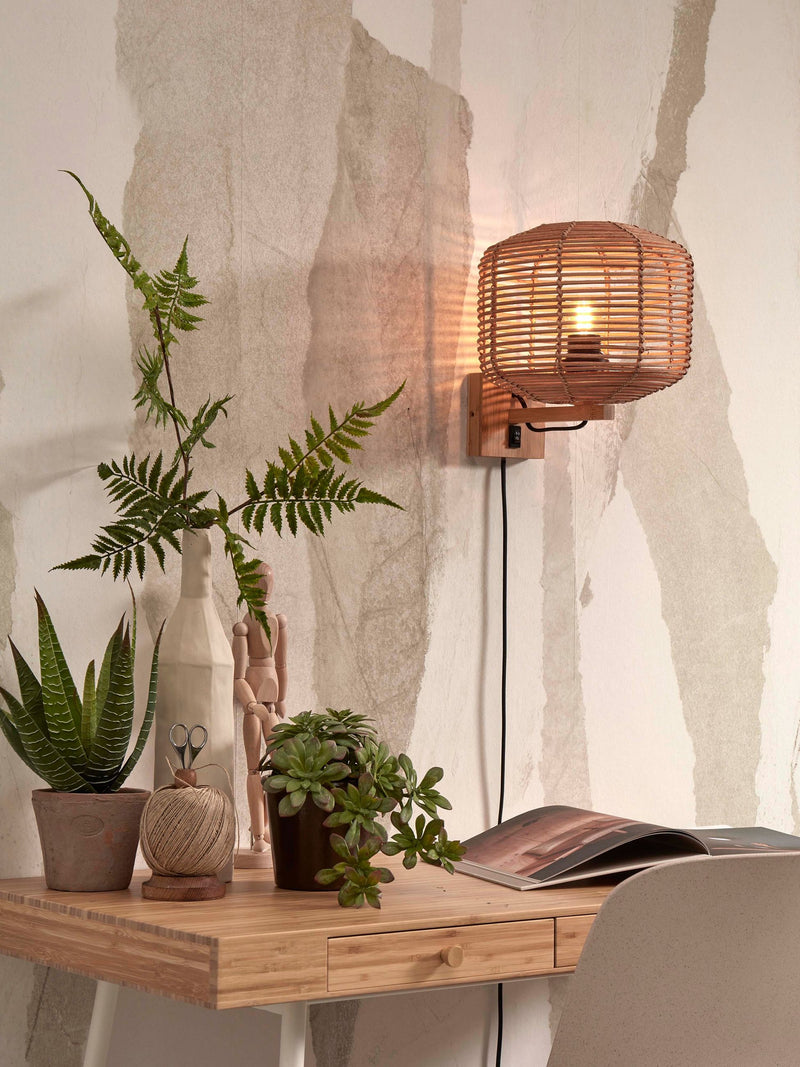 Gesamtansicht der Wandleuchte Tanami von Good&Mojo mit natürlichem Rattanschirm, beleuchtet über einem Holzschreibtisch.