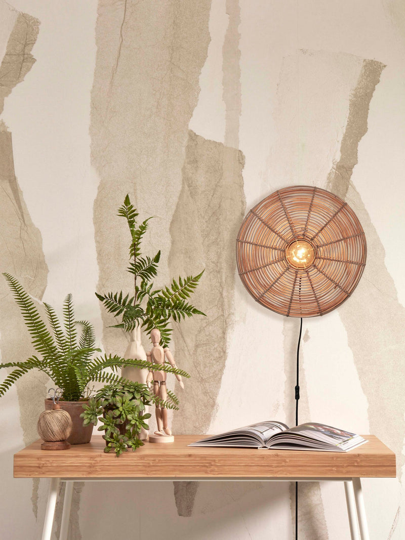 Good&Mojo Wandleuchte Tanami aus Rattan in Natur, an der Wand über einem Holztisch mit Pflanzen und Deko.