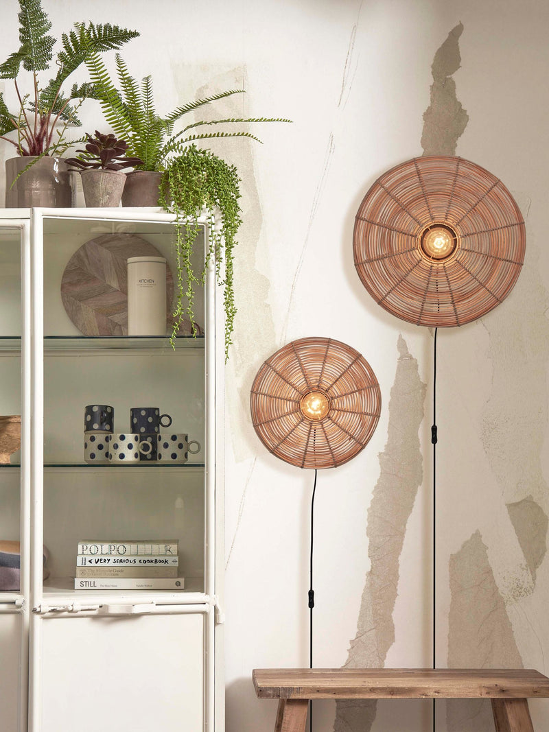 Zwei runde Wandleuchten Tanami aus geflochtenem Rattan in Natur mit sichtbarer Glühlampe, an einer hellen Wand montiert.