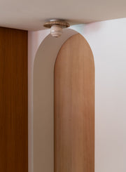 Wand- und Deckenleuchte RoMi Tivoli in Sand: Detailansicht der Travertin-Scheibe mit Glasschirm an der Decke.