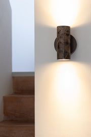 Wandleuchte Tivoli von RoMi in Braun aus Marmor, an der Wand montiert, warmes Licht nach oben und unten.