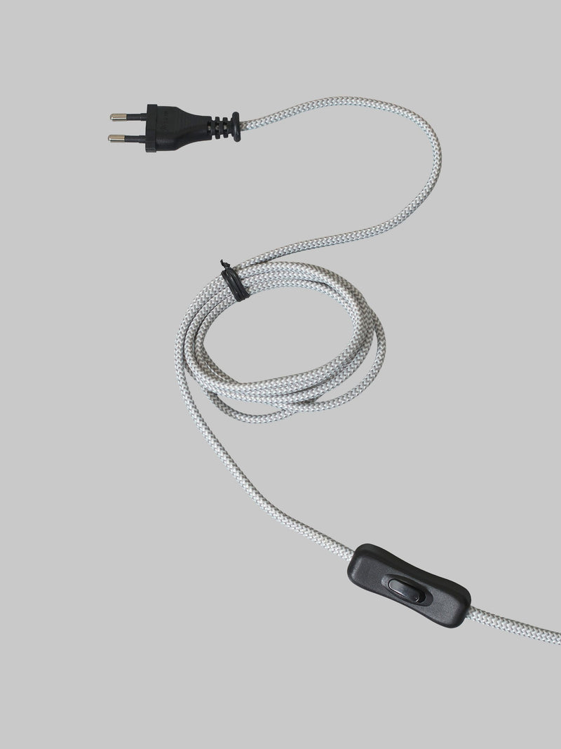 Detailaufnahme des weiß-grau melierten Textilkabels mit schwarzem Euro-Stecker und Kabelschalter vor grauem Hintergrund.