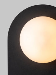 It’s about RoMi Wandleuchte Tokyo: Detailansicht der schwarzen Metallblende mit leuchtendem, rundem Mattglasschirm.