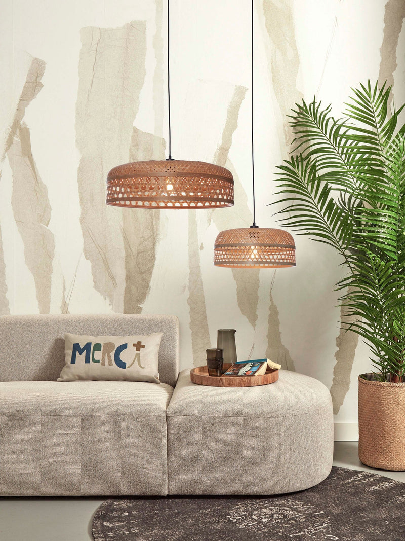 Zwei natürliche Bambus-Hängeleuchten Ubud von Good&Mojo mit geflochtenem Schirm über einem beigen Sofa, daneben eine Palme.