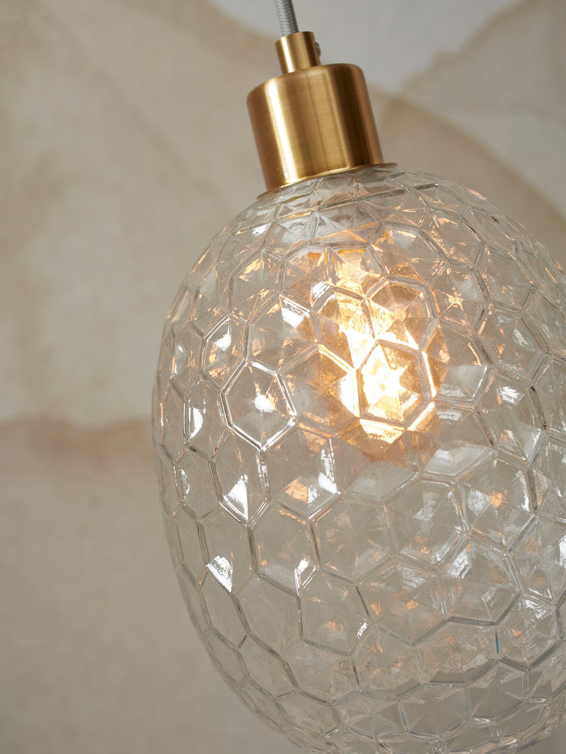 Detailansicht der Hängeleuchte It's about RoMi Venice mit wabenförmigem Klarglas und goldenem Messingkopf.