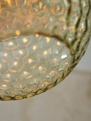Detailaufnahme des grünlich-goldenen Glasschirms der Hängeleuchte It's about RoMi Venice mit warmem Lichtschimmer