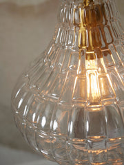 Detailansicht der Hängeleuchte It’s about RoMi Venice aus klarem, geripptem Glas mit eingeschaltetem Leuchtmittel.