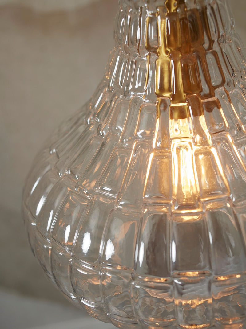 Detailansicht der Hängeleuchte It’s about RoMi Venice aus klarem, geripptem Glas mit eingeschaltetem Leuchtmittel.