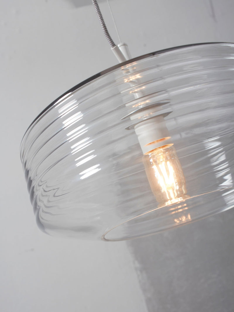 It's about RoMi Hängeleuchte Verona mit geripptem Glasschirm in Klar, Detailansicht von unten mit eingeschalteter Glühlampe.