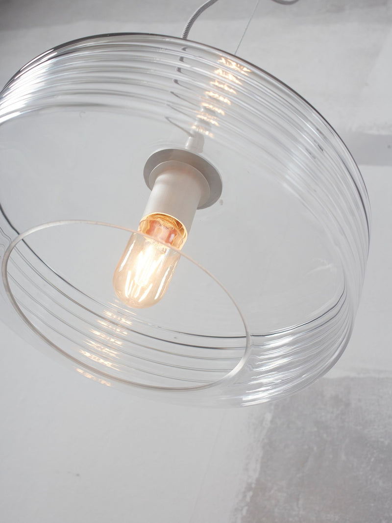 Hängeleuchte Verona mit geripptem Klarglasschirm, Detailansicht von schräg unten mit brennender Glühlampe.