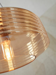 Detailansicht der Hängeleuchte „It's about RoMi Verona" aus bernsteinfarbenem, geripptem Glas, eingeschaltet.