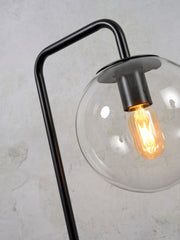 Detailansicht der schwarzen Tischleuchte It's about RoMi Warsaw mit Glaskugel und sichtbar glühender Vintage-Glühlampe.