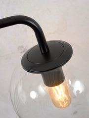 Detailansicht der RoMi Tischleuchte Warsaw mit schwarzer Eisenarmatur, transparenter Glaskugel und sichtbarer Glühlampe.