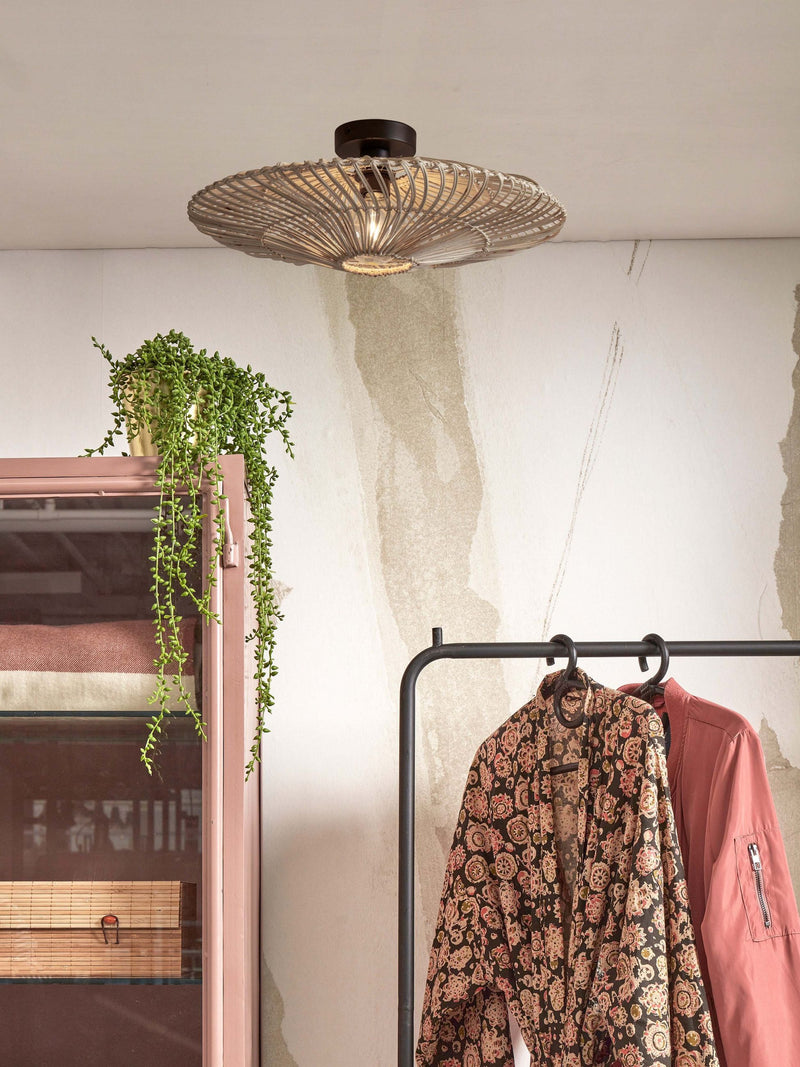 Deckenleuchte Zanzibar von Good&Mojo aus weißem Rattan mit schwarzem Eisengestell über einem Kleiderständer.