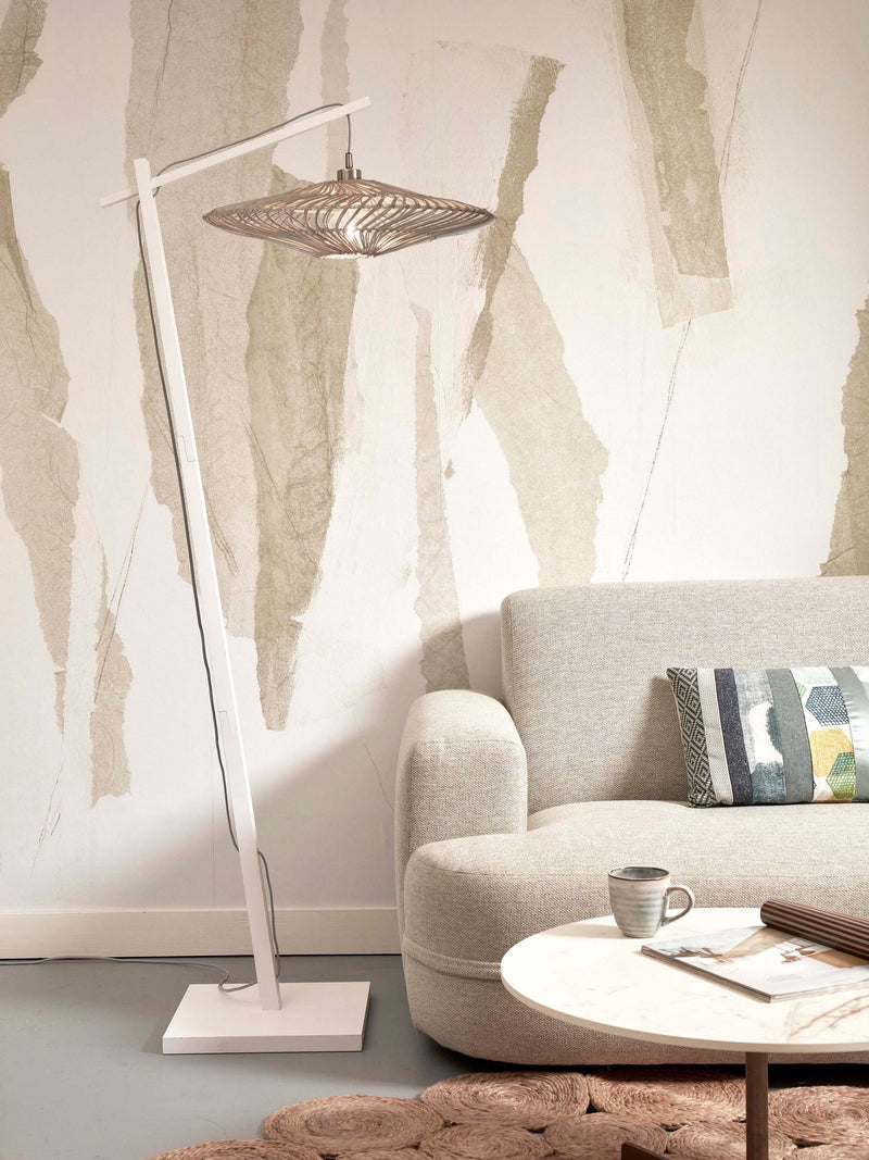Stehleuchte Zanzibar in Weiß mit geschwungenem Rattanschirm, neben einem Sofa in Beige im Wohnzimmer.