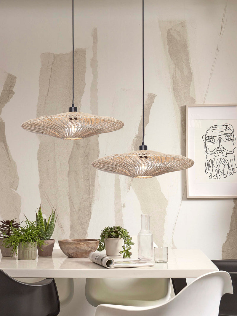 Zwei weiße Hängeleuchten Zanzibar aus Rattan mit schwarzem Kabel über einem weißen Esstisch mit Pflanzen und Dekoration.