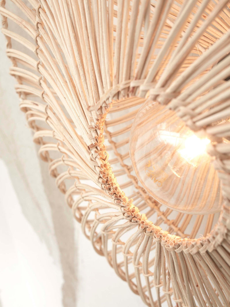 Detailansicht der Good&Mojo Wandleuchte Zanzibar flach mit weißem Rattanschirm und brennender Glühbirne.