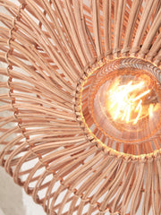 Detailansicht der Good&Mojo Wandleuchte Zanzibar: Der geflochtene Rattanschirm umrahmt eine Glühlampe.