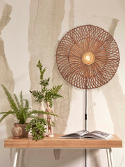 Gesamtansicht der Wandleuchte Zanzibar von Good&Mojo mit rundem Rattan-Schirm in Naturtönen über einem Bambusschreibtisch.