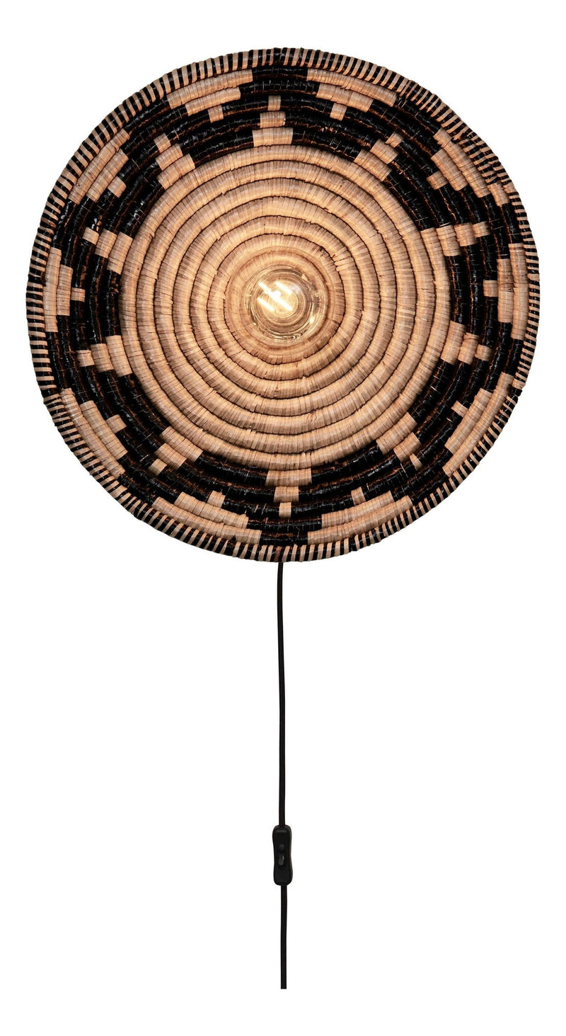 Runde Wandleuchte Andros aus Seegras in Schwarz und Natur mit Spiralmuster, eingeschaltet mit sichtbarer Glühlampe.