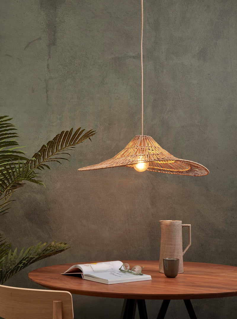 Hängeleuchte Cuzco von Good&Mojo aus Jute in Naturfarbe, hängt brennend über einem runden Holztisch mit Buch und Keramikkrug.