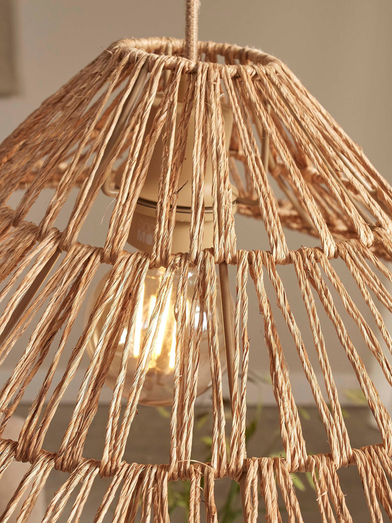 Detailansicht der Hängeleuchte Good&Mojo Cuzco: geflochtener Jute-Schirm mit Blick auf die brennende Glühlampe im Inneren.