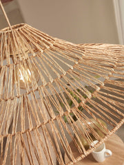 Detailansicht der Hängeleuchte Good&Mojo Cuzco mit geflochtenem Jute-Schirm in Natur, eingeschaltet mit warm leuchtender Glühlampe.