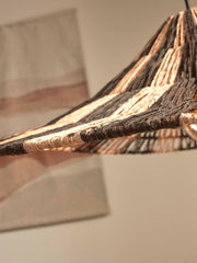 Detailansicht der Hängeleuchte Good&Mojo Cuzco mit geflochtenem Jute-Schirm in Schwarz und Natur, von unten beleuchtet.