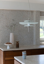 RoMi Hängeleuchte Kyoto in Sand: Mehrere flache, helle Glasschirme hängen über einer Küchenarbeitsplatte mit Terrazzo-Optik.
