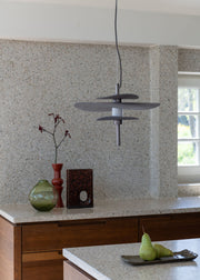 Pendelleuchte It's about RoMi Kyoto in Bronze mit drei flachen Schirmen über einer Küchenarbeitsplatte mit Terrazzo-Oberfläche.